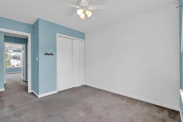 unfurnished bedroom with a closet, baseboards, carpet flooring, and attic access