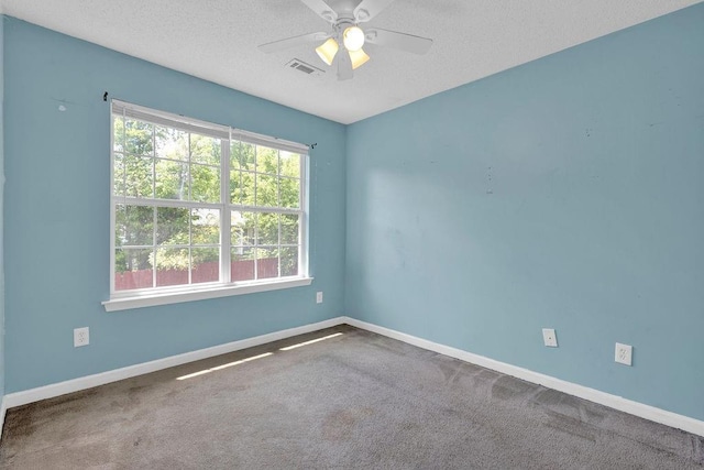 spare room featuring baseboards, a ceiling fan, carpet flooring, and visible vents