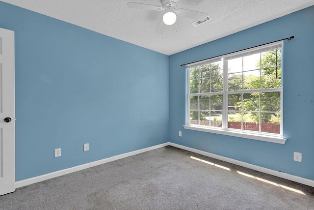 carpeted empty room featuring baseboards, a ceiling fan, a textured ceiling, and visible vents
