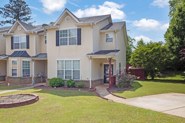 view of front of property featuring brick siding, a front lawn, and stucco siding
