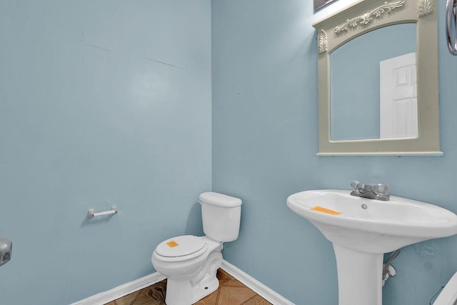 bathroom with toilet and baseboards