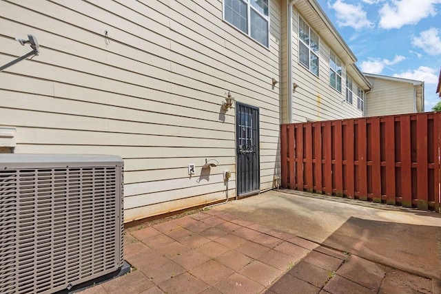 view of home's exterior featuring central AC unit, a patio area, and fence