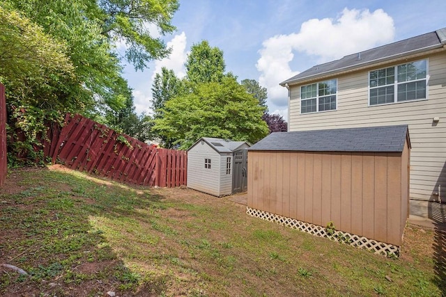 view of yard featuring fence, an outbuilding, and a shed