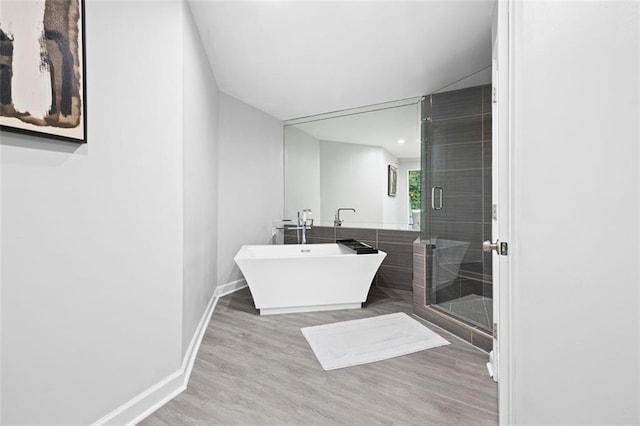 bathroom featuring hardwood / wood-style floors and plus walk in shower