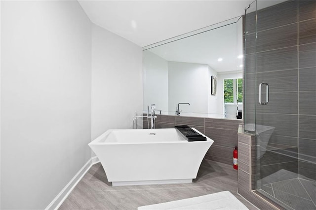 bathroom featuring separate shower and tub and hardwood / wood-style floors