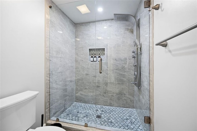 bathroom featuring toilet and an enclosed shower