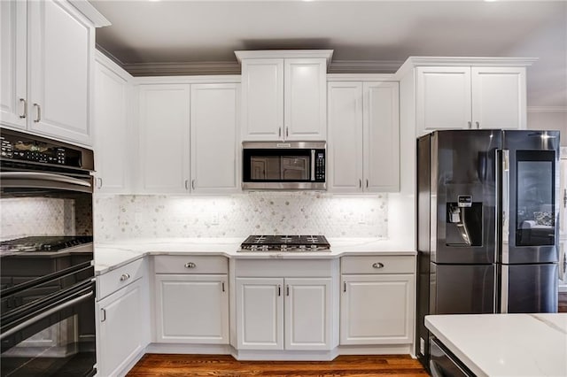 kitchen featuring stainless steel appliances, decorative backsplash, and white cabinetry