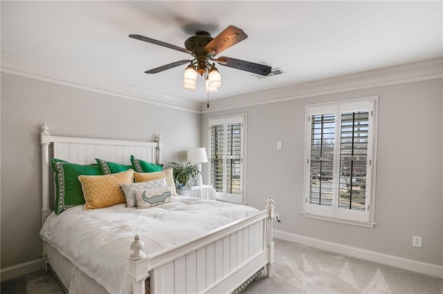 carpeted bedroom with visible vents, a ceiling fan, crown molding, and baseboards