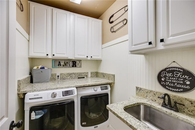 washroom featuring a sink, cabinet space, and separate washer and dryer