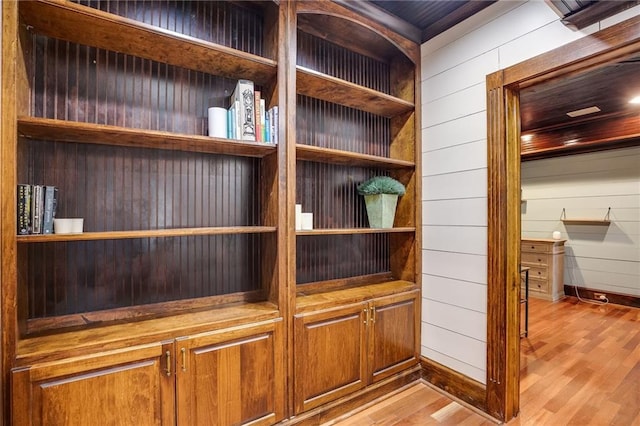 room details with wooden walls, baseboards, and wood finished floors