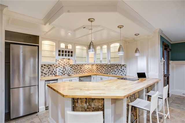 kitchen featuring wood counters, tasteful backsplash, and appliances with stainless steel finishes