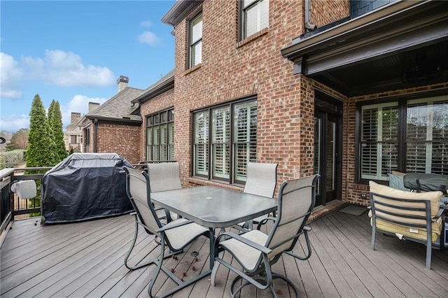 deck featuring outdoor dining space and a grill