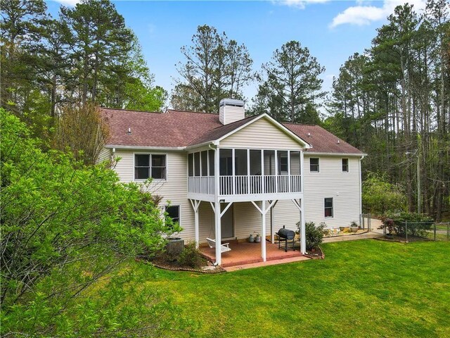 back of property featuring a sunroom, central AC unit, a yard, and a patio