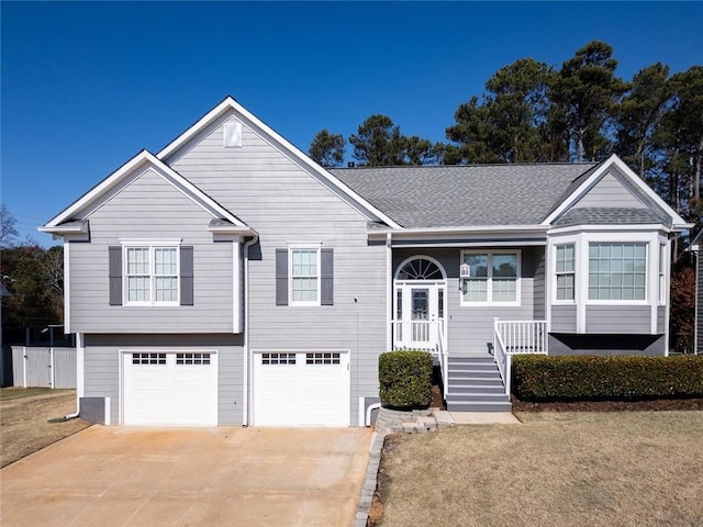 raised ranch featuring a front yard and a garage