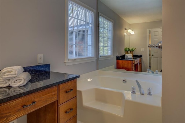 bathroom with vanity and a bath