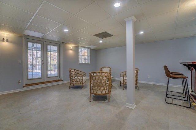 living area with french doors and a drop ceiling