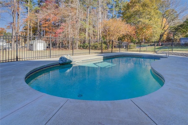 view of pool featuring a storage shed and a patio