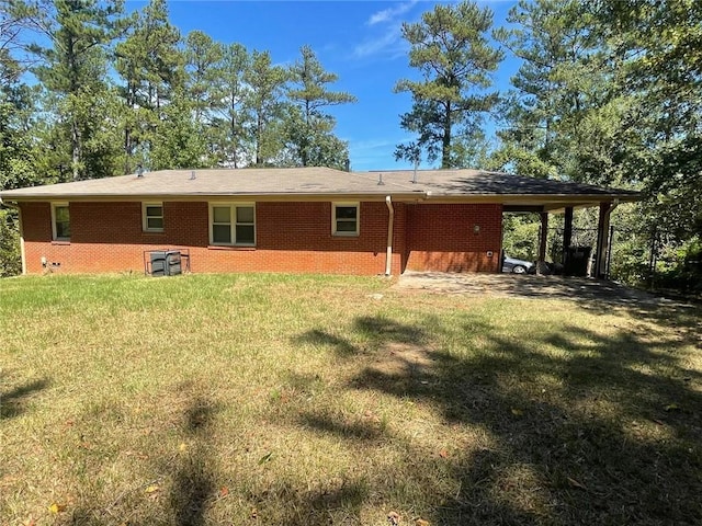 rear view of property featuring a yard and a carport