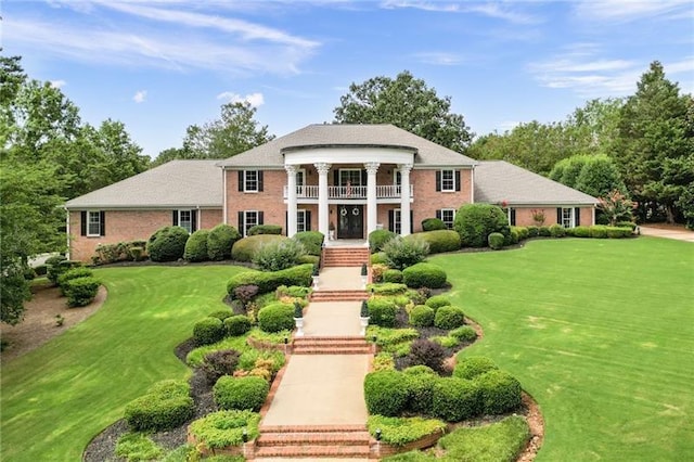 greek revival house with a balcony and a front lawn