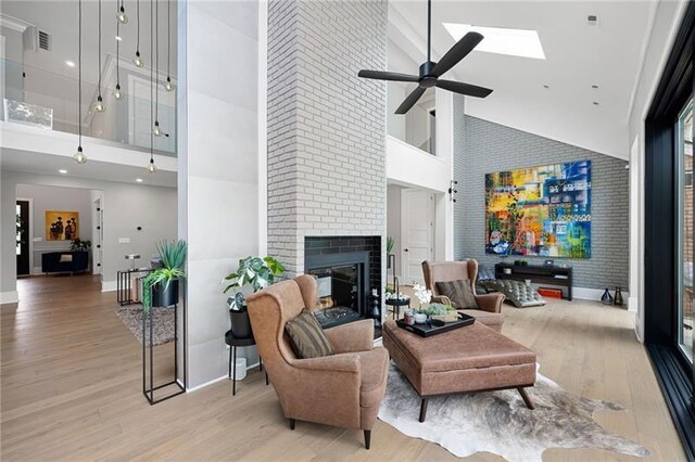 living room with a fireplace, high vaulted ceiling, and light hardwood / wood-style flooring