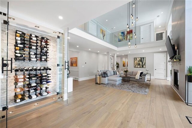 living room with light hardwood / wood-style floors and a high ceiling