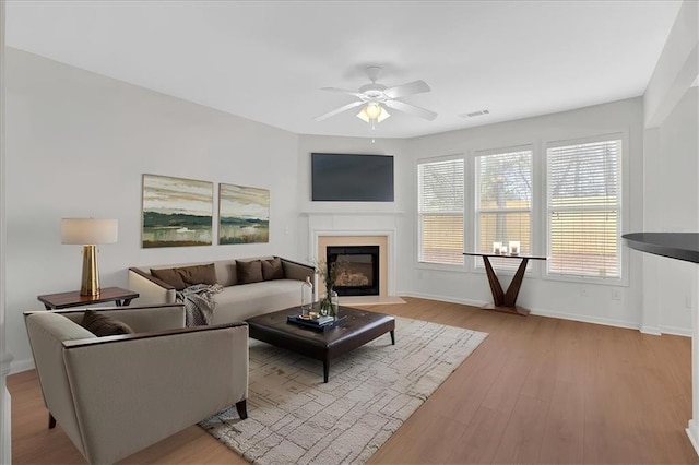 living room featuring ceiling fan and light hardwood / wood-style flooring