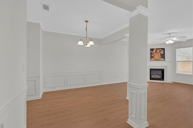 1795 Waterside Dr NW, Kennesaw, GA 30152 - unfurnished living room with ceiling fan with notable chandelier, light hardwood / wood-style flooring, ornamental molding, and ornate columns