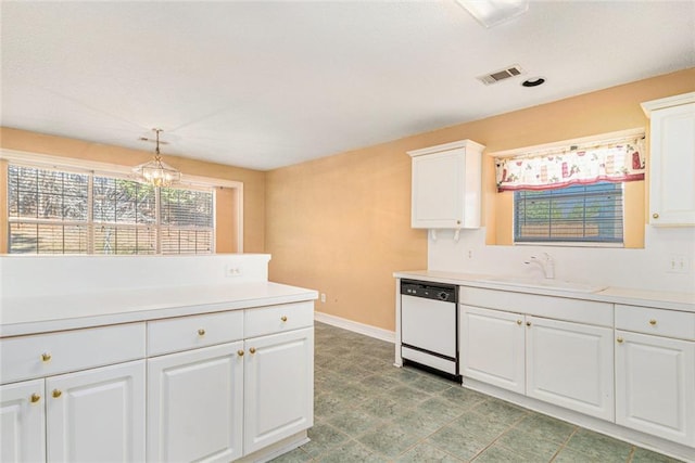 kitchen featuring light countertops, white dishwasher, decorative light fixtures, and white cabinets