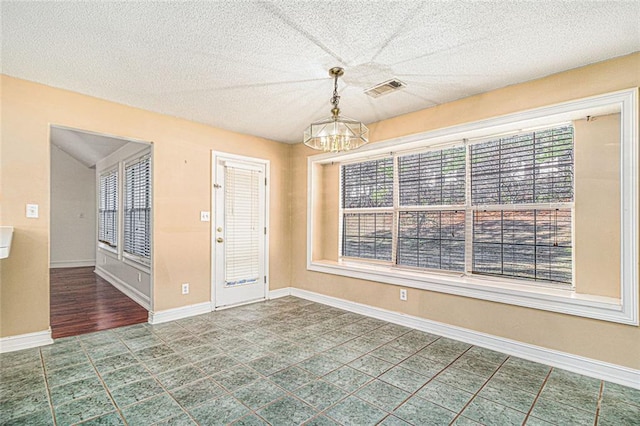 interior space with baseboards, visible vents, a chandelier, and a textured ceiling