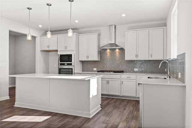 kitchen with sink, a center island, wall chimney exhaust hood, and oven