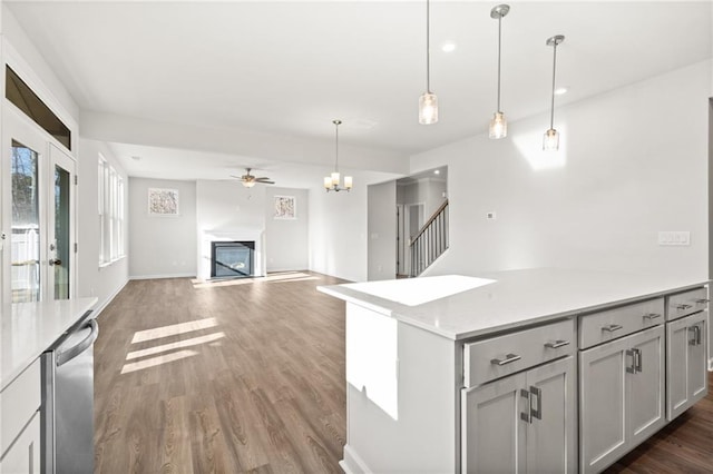 kitchen featuring dishwasher, hanging light fixtures, gray cabinetry, dark wood-type flooring, and ceiling fan