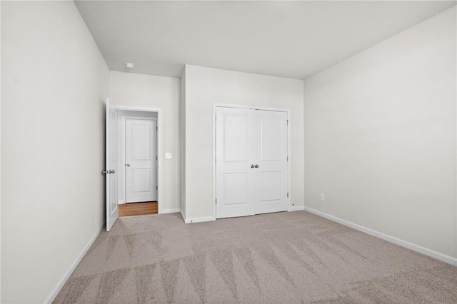 unfurnished bedroom featuring a closet and light carpet