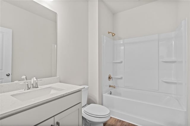 full bathroom with hardwood / wood-style floors, toilet, vanity, and  shower combination