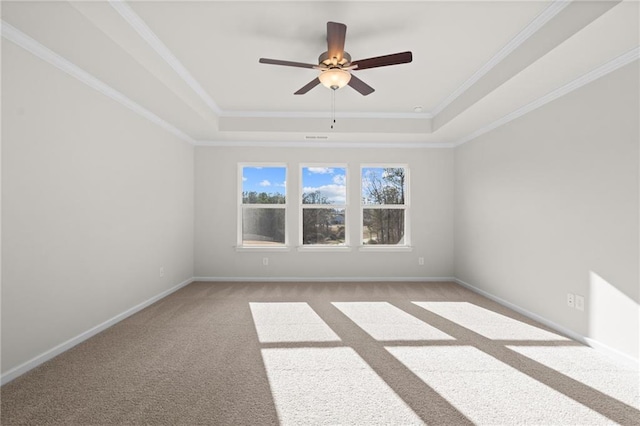 carpeted spare room featuring ceiling fan, a tray ceiling, and crown molding