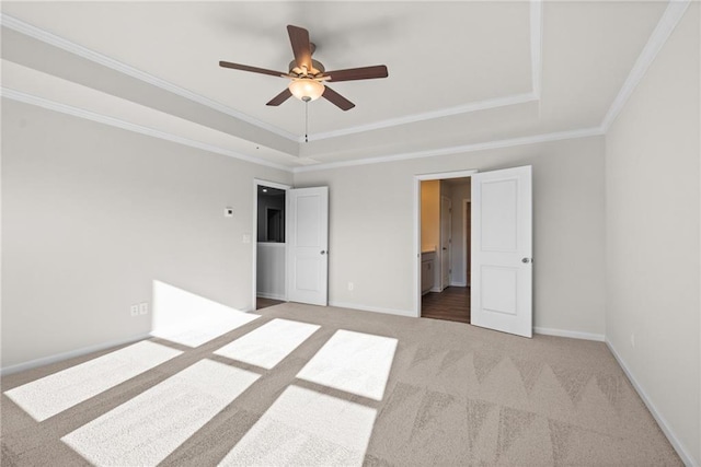 unfurnished bedroom with crown molding, carpet floors, and a tray ceiling