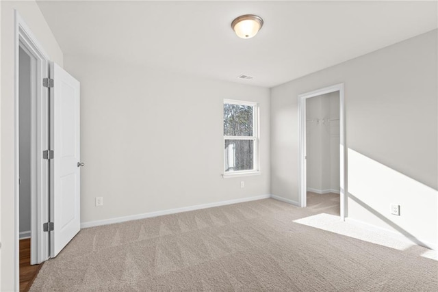 unfurnished bedroom featuring a closet and light carpet