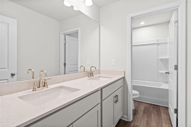 bathroom featuring wood-type flooring, toilet, and vanity