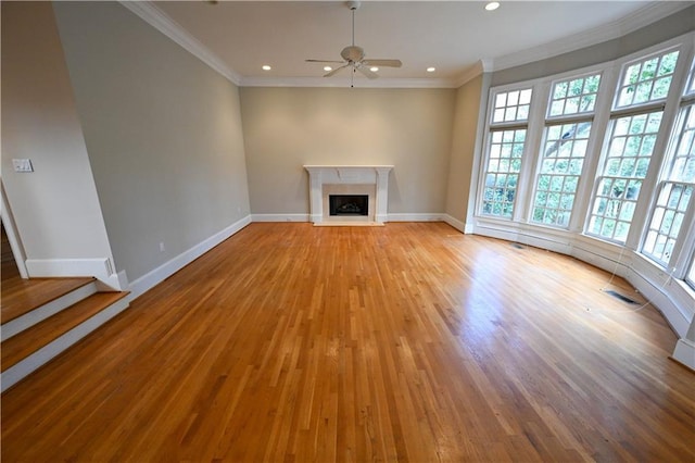 unfurnished living room featuring light wood-type flooring, ceiling fan, and ornamental molding