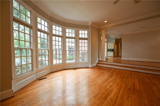spare room with light wood-type flooring and crown molding