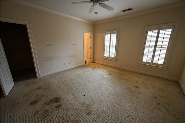 unfurnished bedroom featuring a walk in closet, light carpet, ceiling fan, and multiple windows
