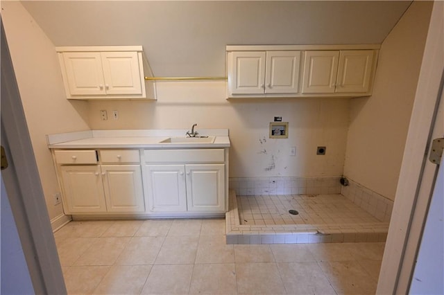 washroom featuring cabinets, washer hookup, electric dryer hookup, sink, and light tile patterned floors