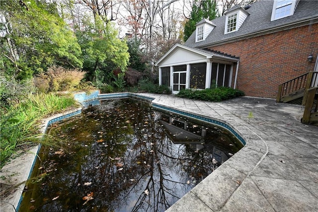view of swimming pool featuring a patio area and a sunroom