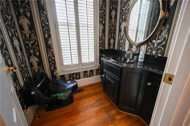 bathroom with hardwood / wood-style floors, vanity, and toilet