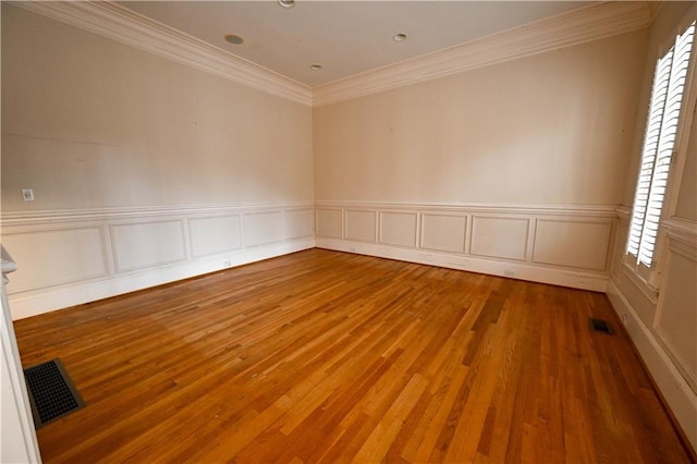unfurnished room featuring wood-type flooring, a healthy amount of sunlight, and ornamental molding