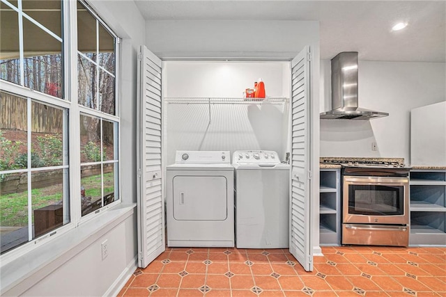 laundry room with washer and clothes dryer and light tile patterned floors