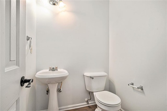 bathroom with wood-type flooring and toilet