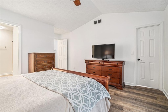 bedroom featuring lofted ceiling, dark wood-type flooring, ceiling fan, and ensuite bath