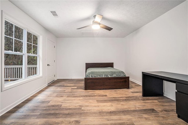 unfurnished bedroom with ceiling fan, hardwood / wood-style floors, and a textured ceiling