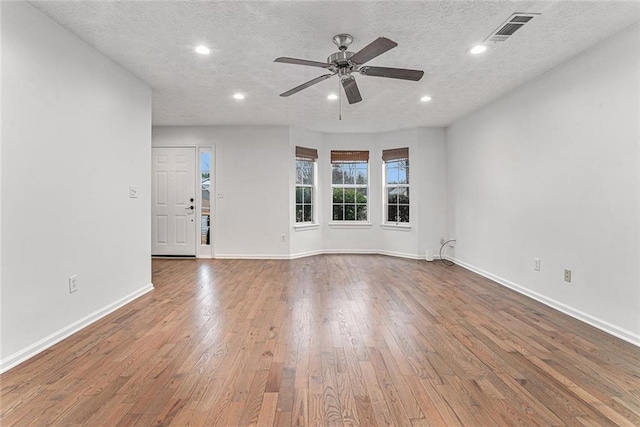 interior space featuring ceiling fan, hardwood / wood-style floors, and a textured ceiling