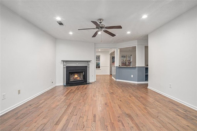 unfurnished living room with ceiling fan, sink, and light wood-type flooring